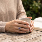 [KI] Amethystring aus Silber getragen beim Lesen mit einer Tasse