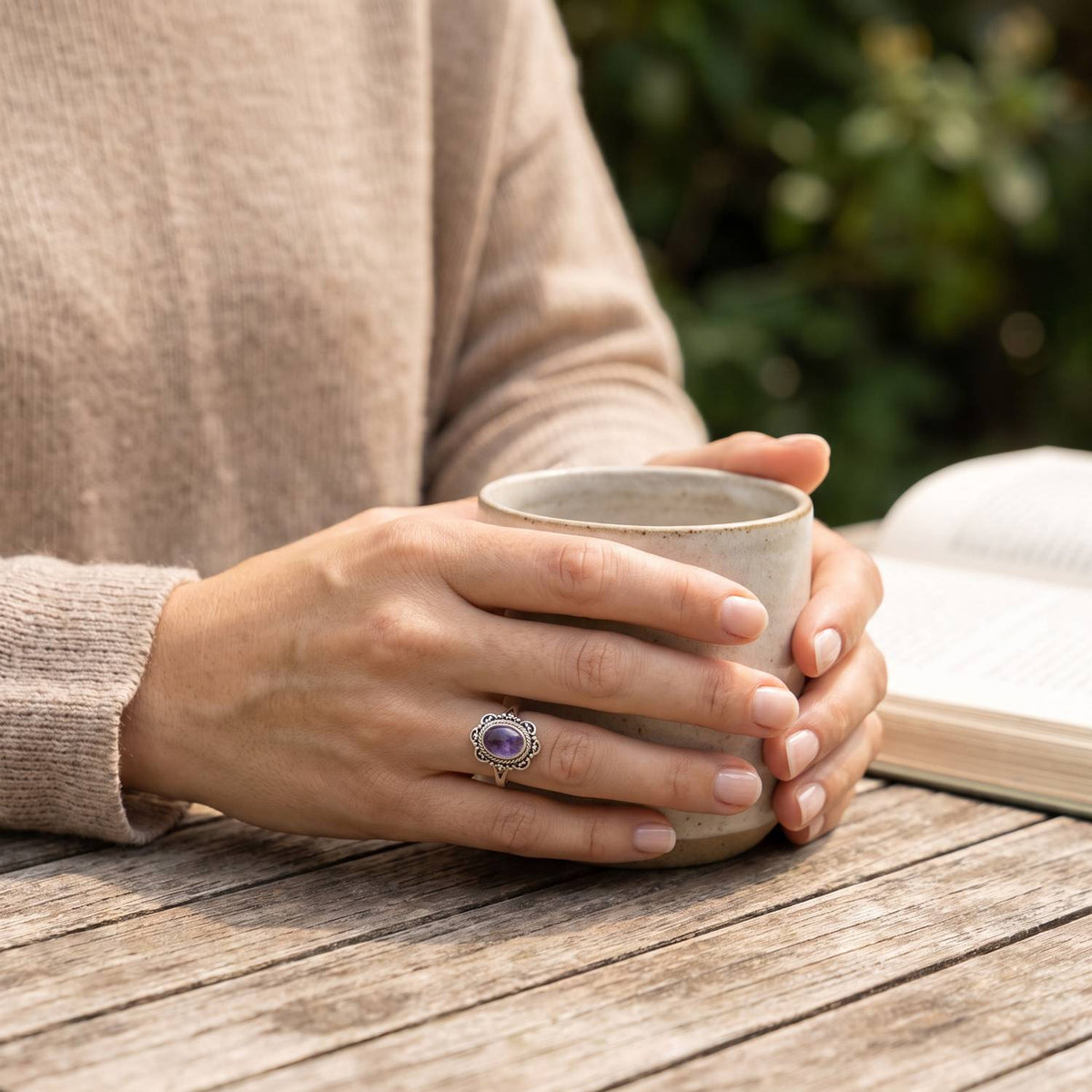 Amethystring aus Silber getragen beim Lesen mit einer Tasse