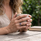 [KI] Amethystring aus Silber getragen beim Lesen mit einer Tasse