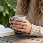[KI] Amethystring aus Silber getragen beim Lesen mit einer Tasse