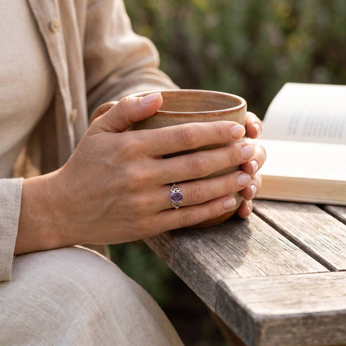 Amethystring aus Silber getragen beim Lesen mit einer Tasse