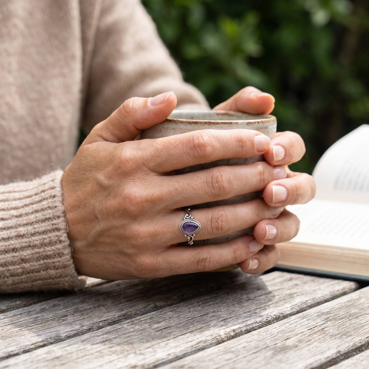 Amethystring aus Silber getragen beim Lesen mit einer Tasse