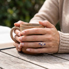 [KI] Amethystring aus Silber getragen beim Lesen mit einer Tasse