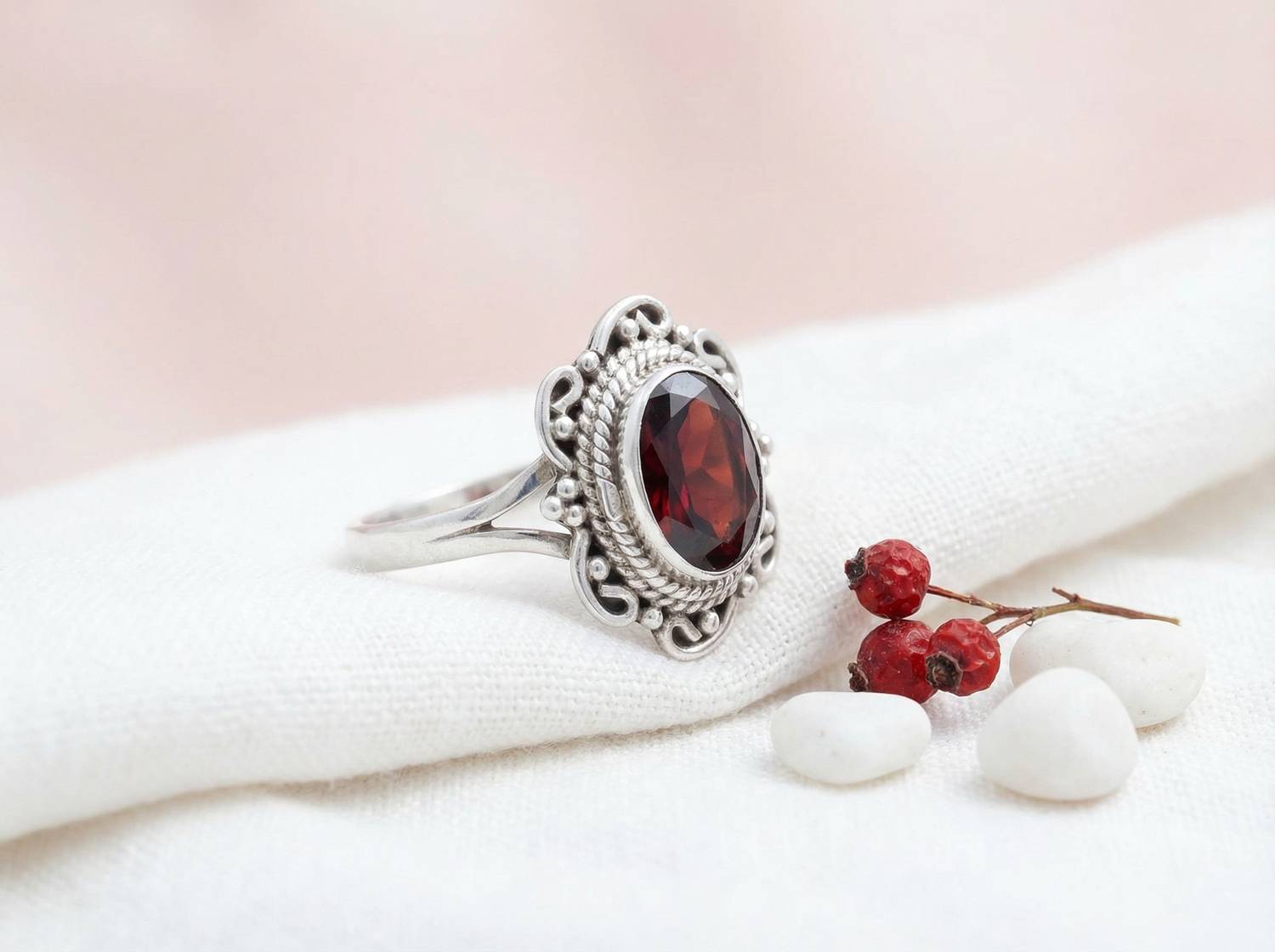 Silberring mit Granat auf hellem Stoff