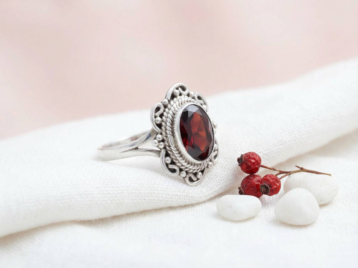 Silberring mit Granat auf hellem Stoff