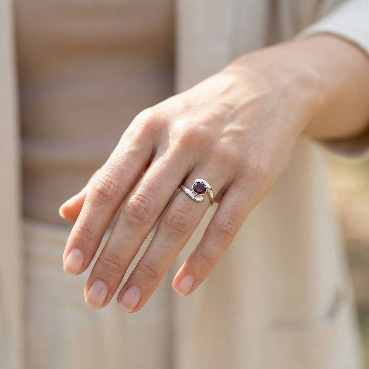 Granatring aus Silber getragen an der Hand im Freien