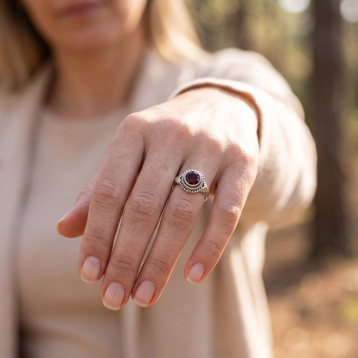 Granatring aus Silber getragen an der Hand im Freien