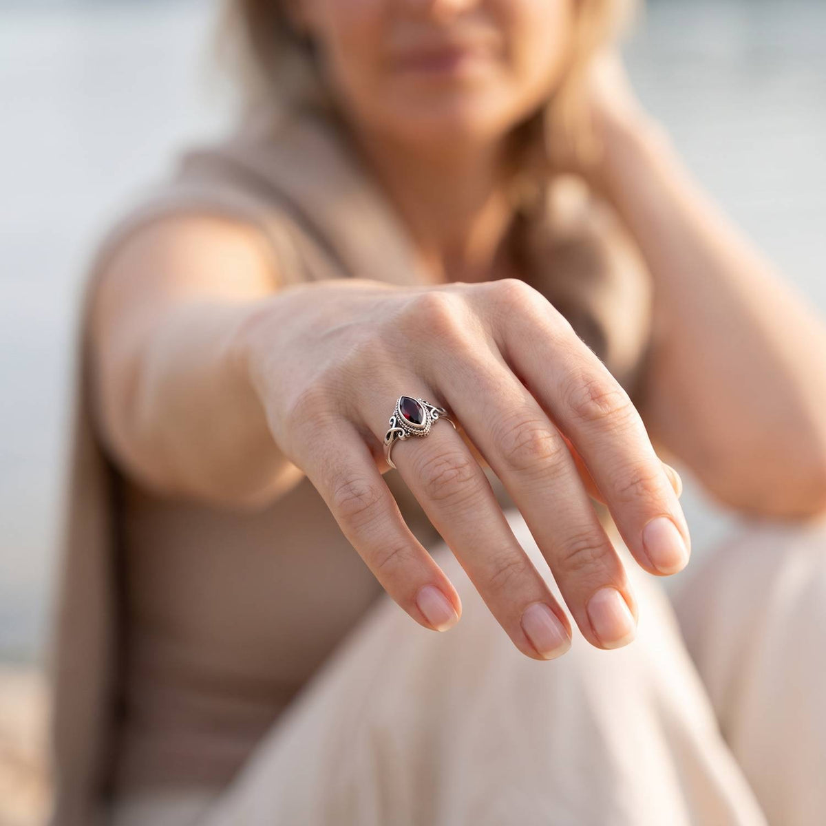 Granatring aus Silber getragen an der Hand im Freien