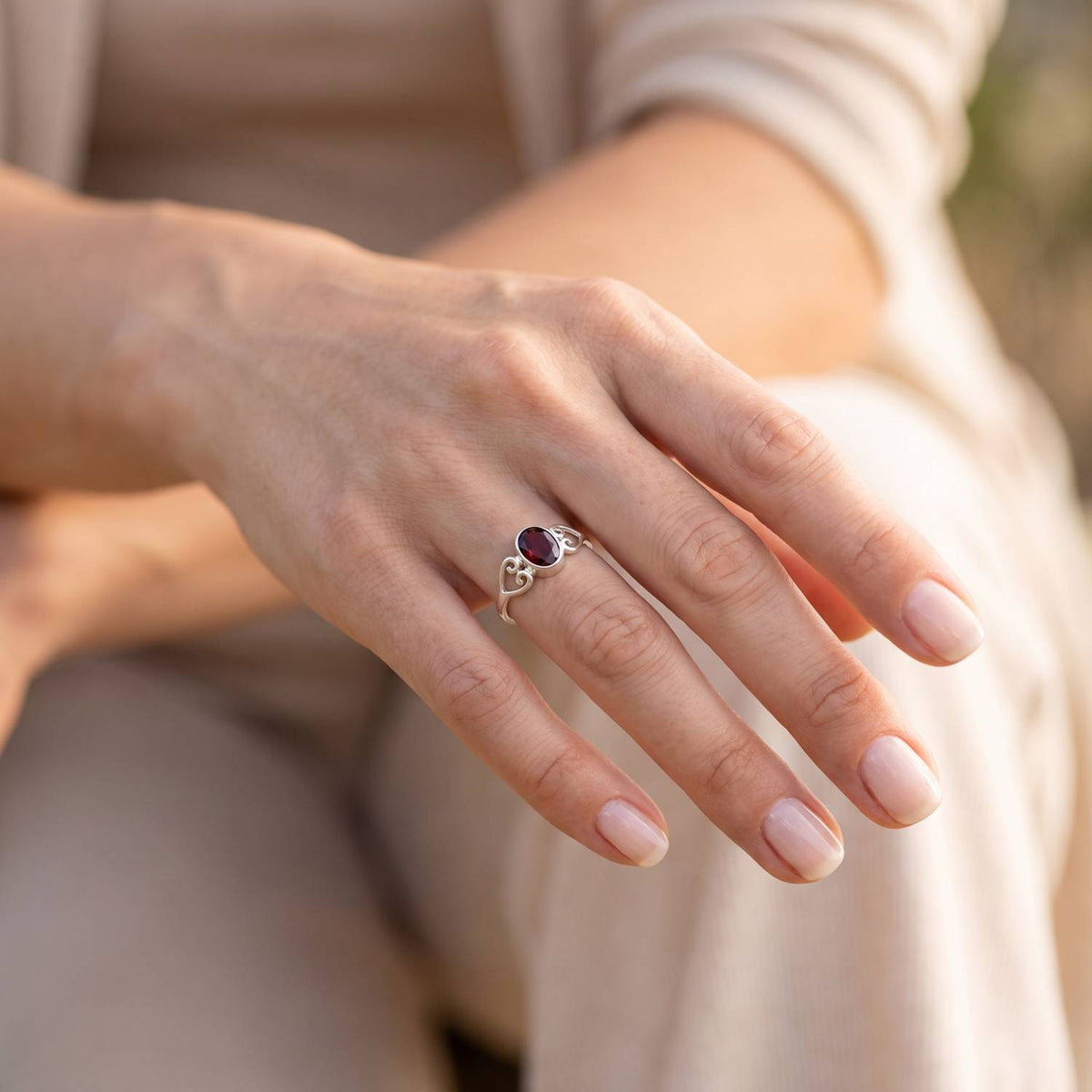 Granatring aus Silber getragen an der Hand im Freien