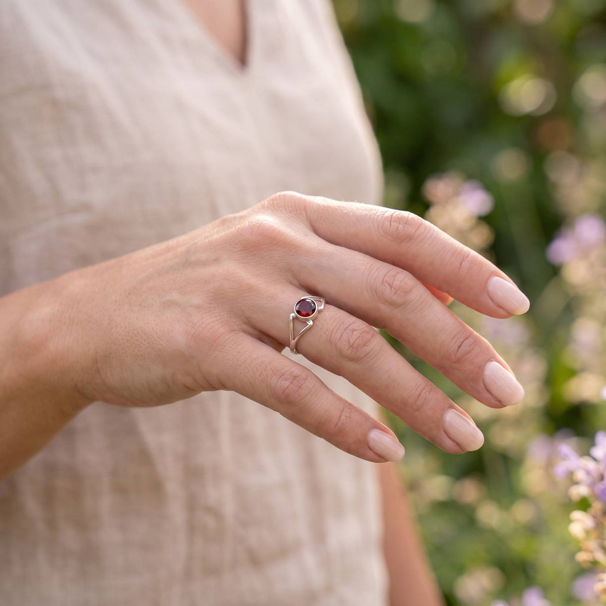 Granatring aus Silber getragen an der Hand im Freien