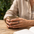 [KI] Granatring aus Silber getragen beim Lesen mit einer Tasse