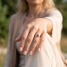 [KI] Granatring aus Silber getragen an der Hand im Freien
