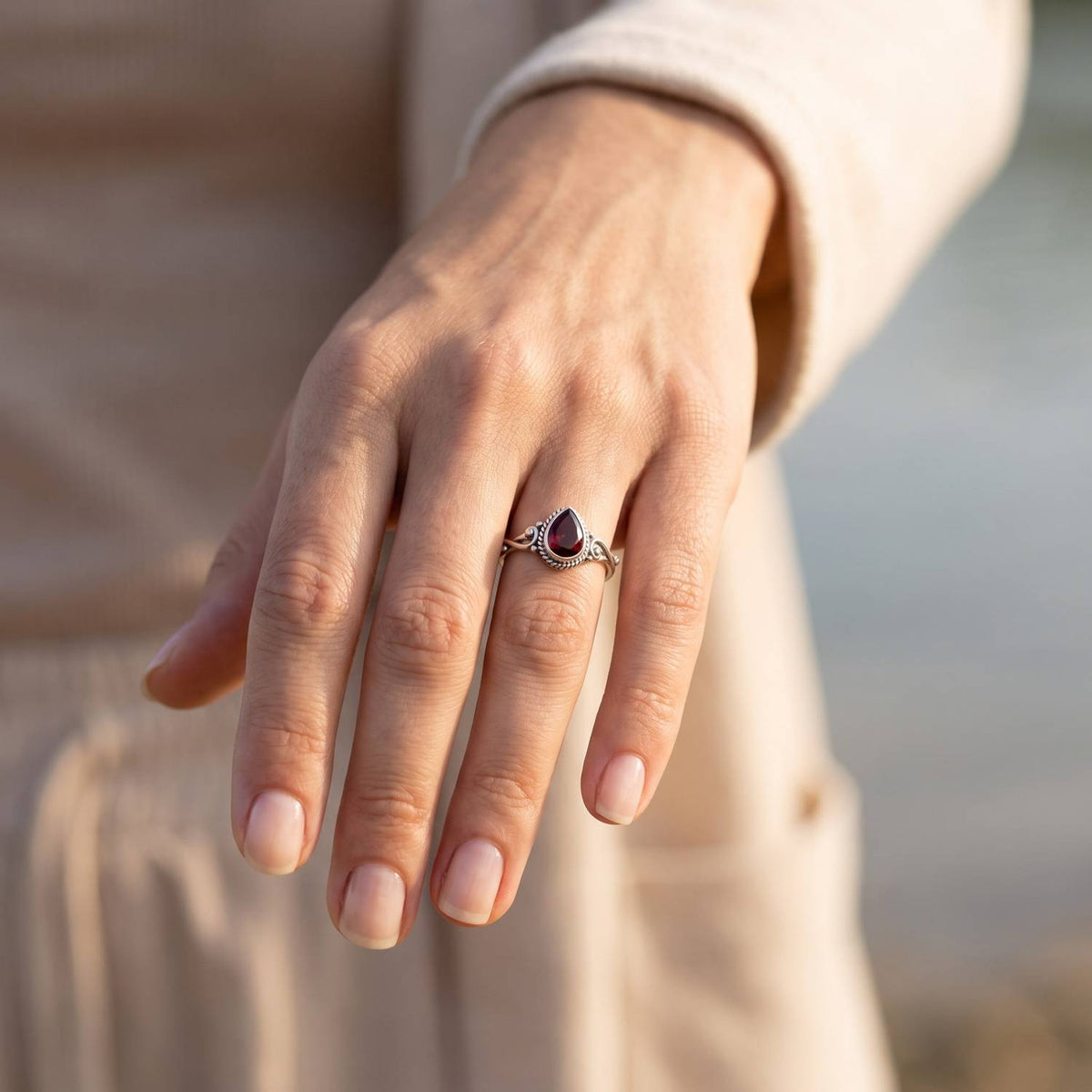 Granatring aus Silber getragen an der Hand im Freien