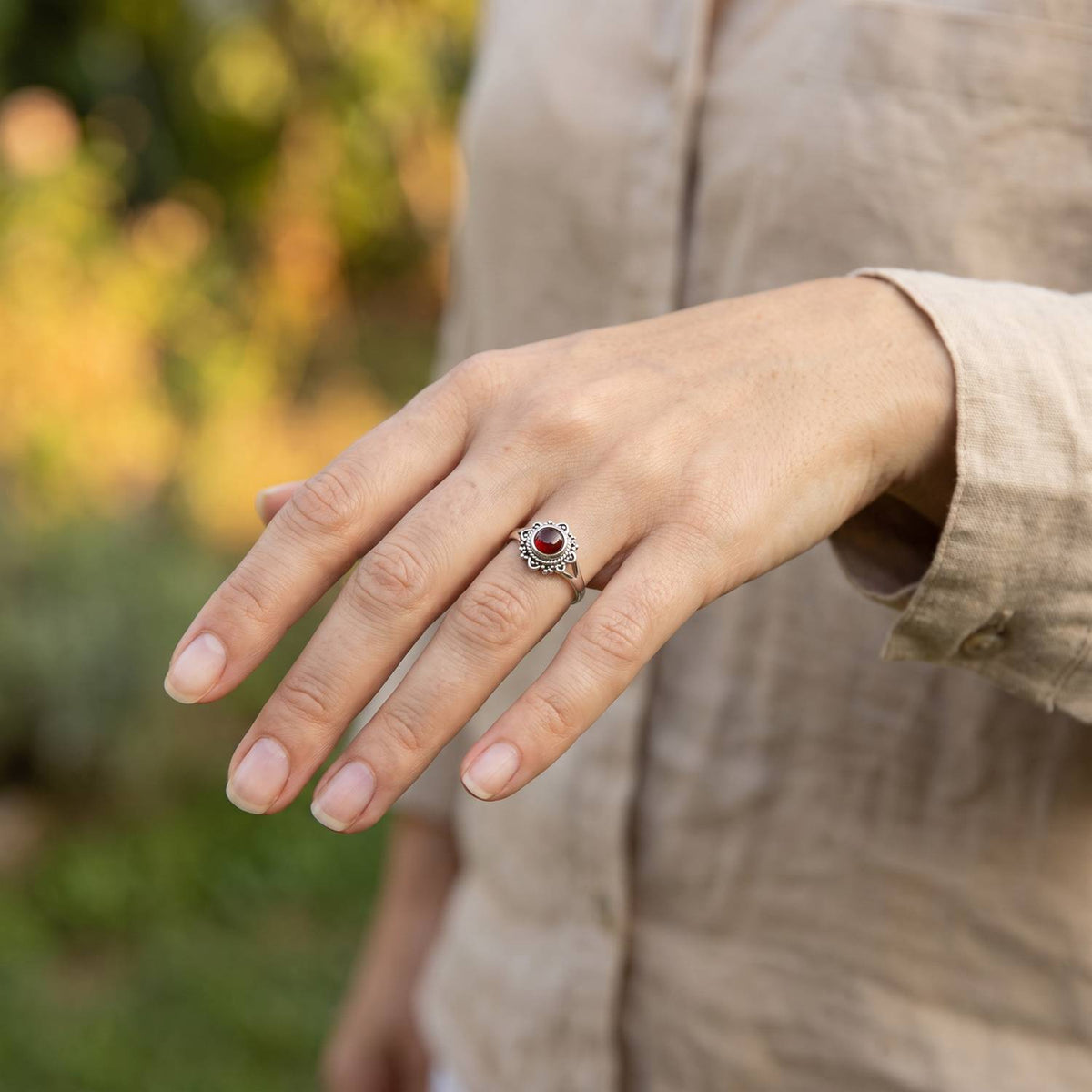 Granatring aus Silber getragen an der Hand im Freien