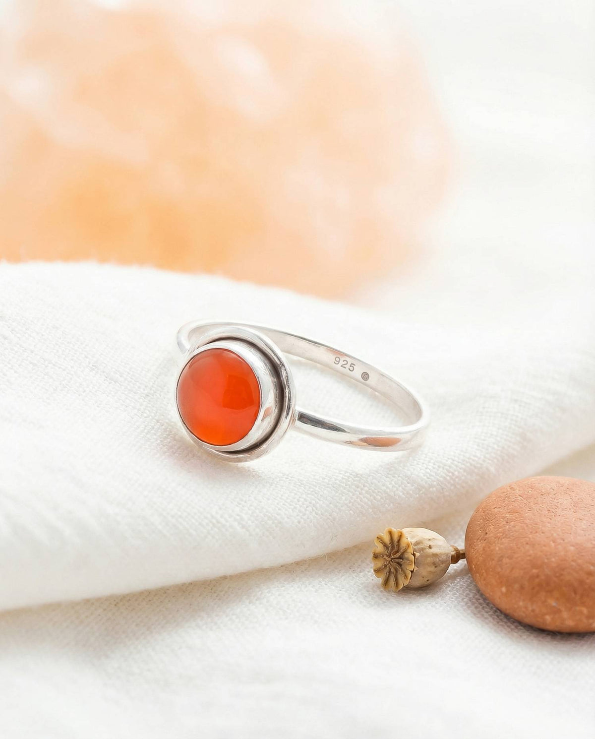 Silberring mit Karneol auf hellem Stoff