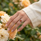 [KI] Silberring mit Karneol an der Hand zwischen Blumen