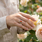 [KI] Silberring mit Karneol an der Hand zwischen Blumen