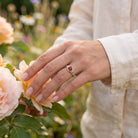 [KI] Silberring mit Karneol an der Hand zwischen Blumen