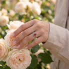 [KI] Silberring mit Karneol an der Hand zwischen Blumen