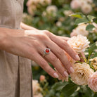 [KI] Silberring mit Karneol an der Hand zwischen Blumen