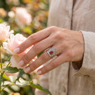[KI] Silberring mit Karneol an der Hand zwischen Blumen
