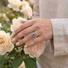 [KI] Silberring mit Karneol an der Hand zwischen Blumen