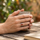 [KI] Karneolring aus Silber getragen beim Lesen mit einer Tasse