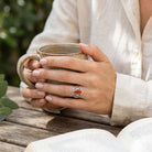 [KI] Karneolring aus Silber getragen beim Lesen mit einer Tasse