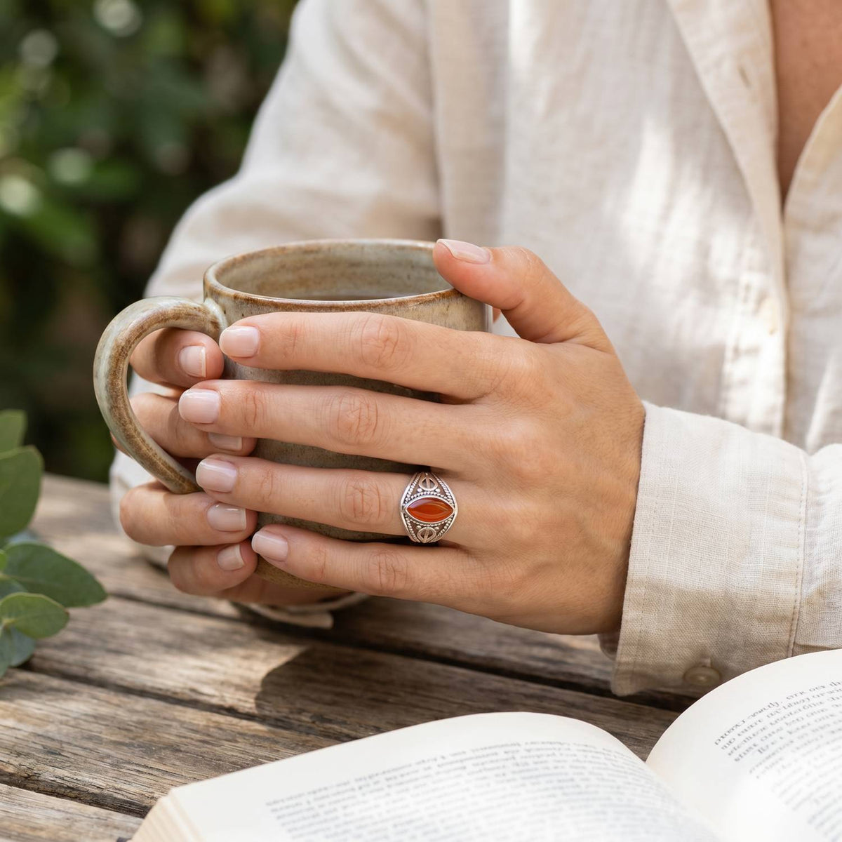 Karneolring aus Silber getragen beim Lesen mit einer Tasse