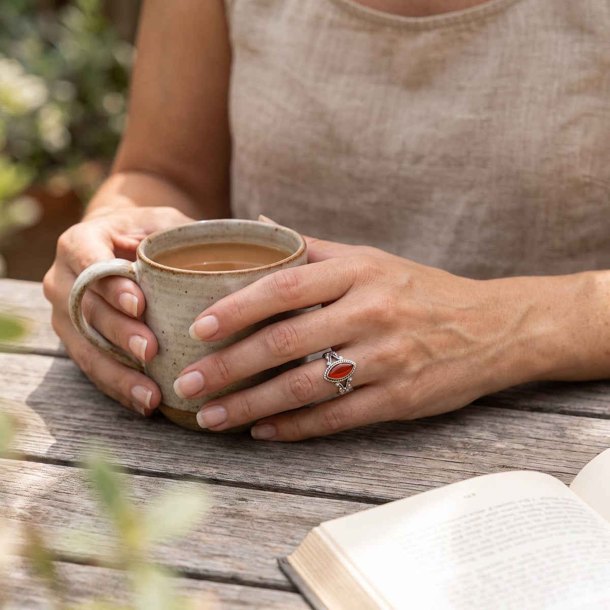 Karneolring aus Silber getragen beim Lesen mit einer Tasse