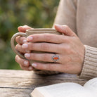 [KI] Karneolring aus Silber getragen beim Lesen mit einer Tasse