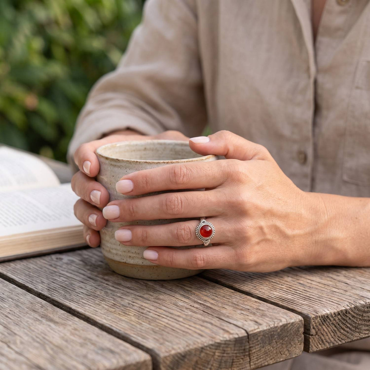 Karneolring aus Silber getragen beim Lesen mit einer Tasse