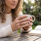 [KI] Karneolring aus Silber getragen beim Lesen mit einer Tasse