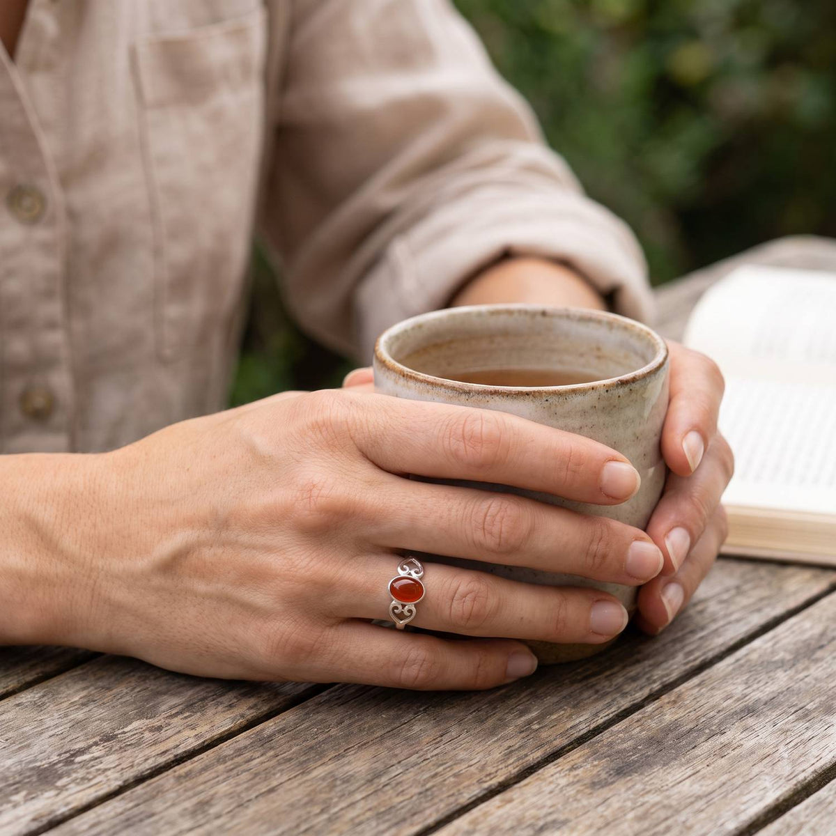 Karneolring aus Silber getragen beim Lesen mit einer Tasse