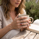 [KI] Karneolring aus Silber getragen beim Lesen mit einer Tasse