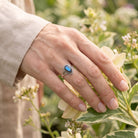 [KI] Silberring mit Labradorit an der Hand zwischen Blumen