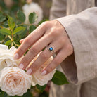 [KI] Silberring mit Labradorit an der Hand zwischen Blumen