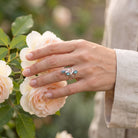 [KI] Silberring mit Labradorit an der Hand zwischen Blumen