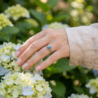 [KI] Silberring mit Labradorit an der Hand zwischen Blumen