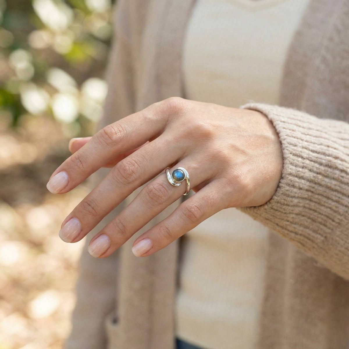 Labradoritring aus Silber getragen an der Hand im Freien