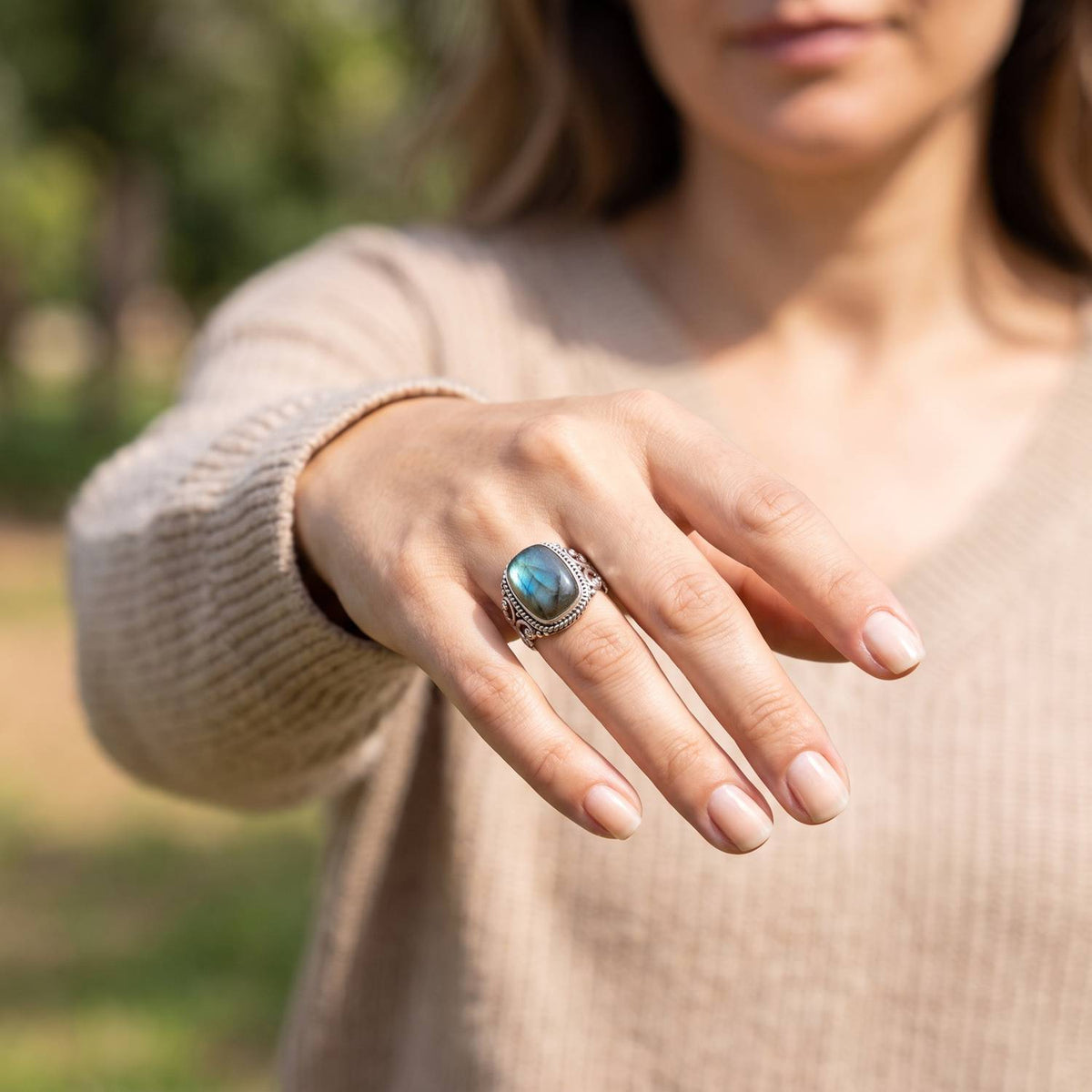 Labradoritring aus Silber getragen an der Hand im Freien