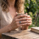 [KI] Labradoritring aus Silber getragen beim Lesen mit einer Tasse