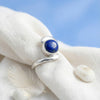 [KI] Silberring mit Lapislazuli auf hellem Stoff
