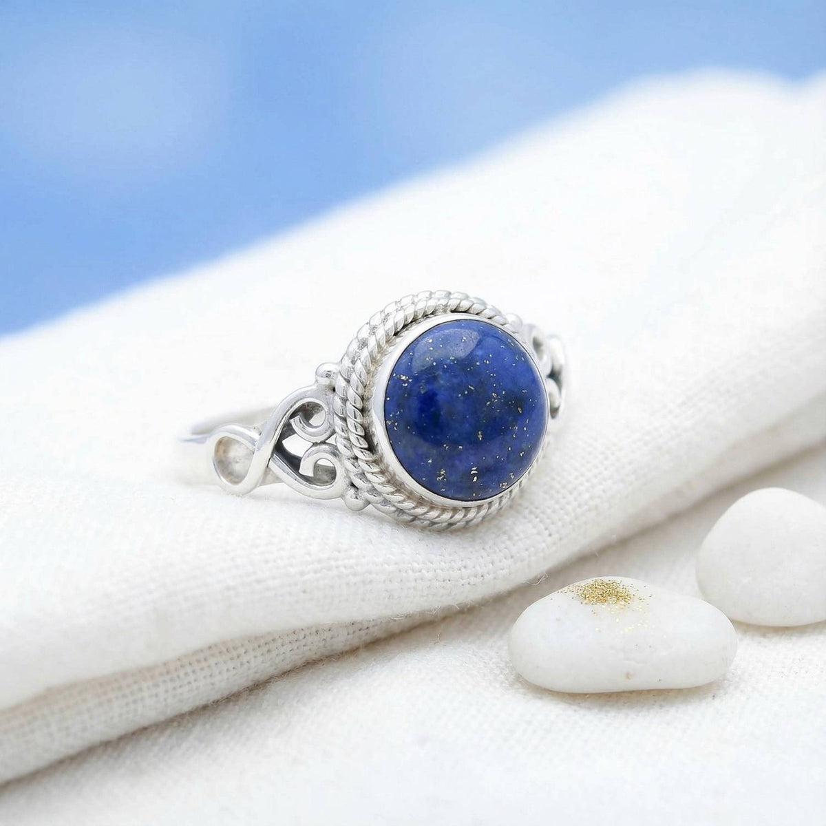 Silberring mit Lapislazuli auf hellem Stoff