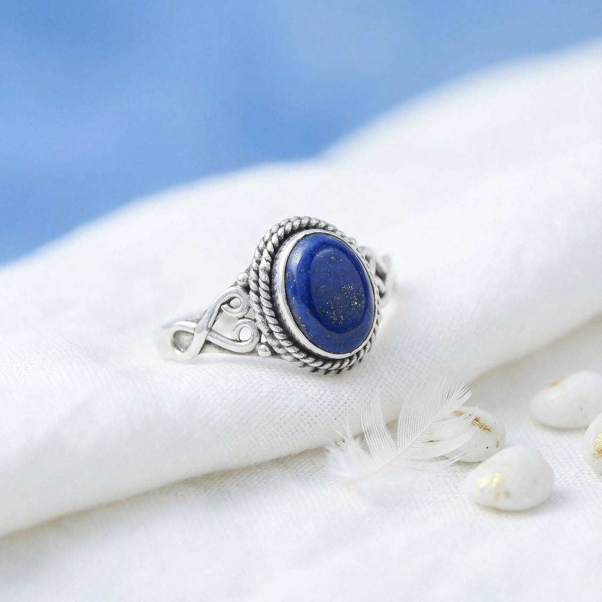 Silberring mit Lapislazuli auf hellem Stoff