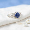 [KI] Silberring mit Lapislazuli auf hellem Stoff