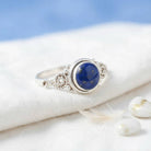 [KI] Silberring mit Lapislazuli auf hellem Stoff