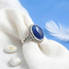 [KI] Silberring mit Lapislazuli auf hellem Stoff