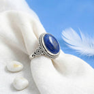 [KI] Silberring mit Lapislazuli auf hellem Stoff