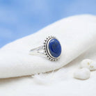 [KI] Silberring mit Lapislazuli auf hellem Stoff